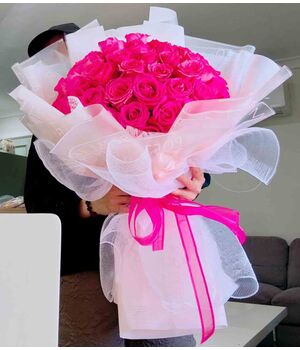 two dozen pink roses in a beautiful bouquet