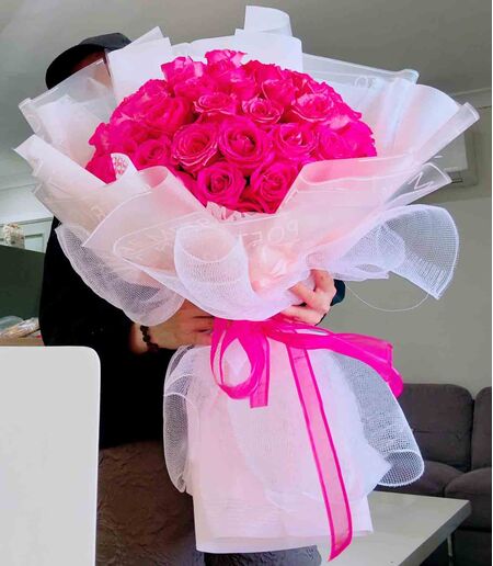 two dozen pink roses in a beautiful bouquet